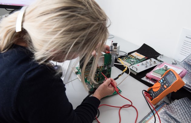 A woman checks the circuit board of her NTD equipment