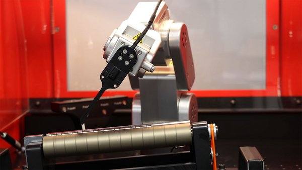 Close-up of the ibg eddyrobot mobile inspection system looking at its components during the inspection of a rotor shaft for quality assurance. The red machine is in the background. 